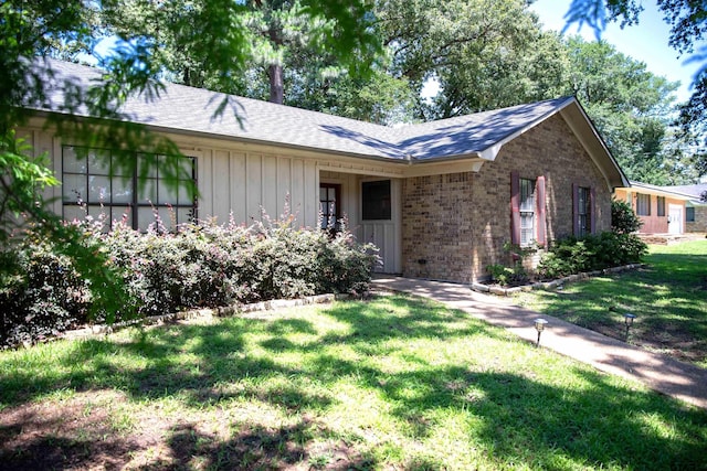 3505 Cloverdale Dr, Tyler, TX 75701 - ranch-style home with a front yard, brick siding, roof with shingles, and board and batten siding