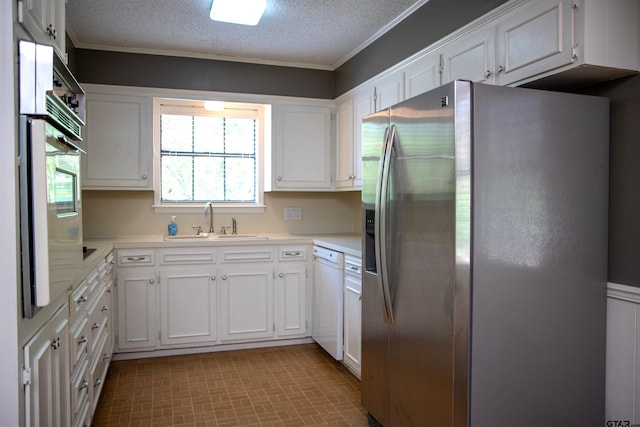3505 Cloverdale Dr, Tyler, TX 75701 - kitchen with stainless steel appliances, a sink, light countertops, white cabinetry, and a textured ceiling