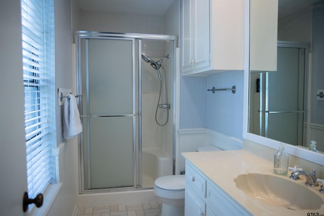 3505 Cloverdale Dr, Tyler, TX 75701 - full bathroom featuring a stall shower, toilet, healthy amount of natural light, vanity, and wainscoting