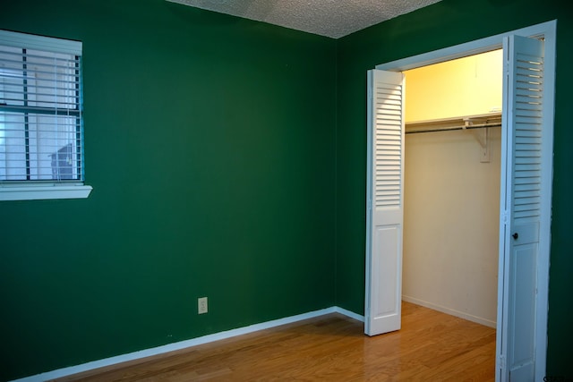 3505 Cloverdale Dr, Tyler, TX 75701 - unfurnished bedroom featuring wood finished floors, a closet, a textured ceiling, and baseboards