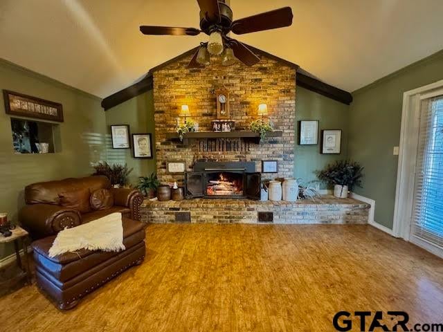 living room featuring a fireplace, hardwood / wood-style flooring, ceiling fan, and lofted ceiling