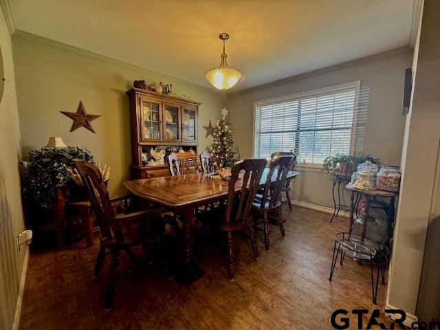 dining room with crown molding and dark wood-type flooring