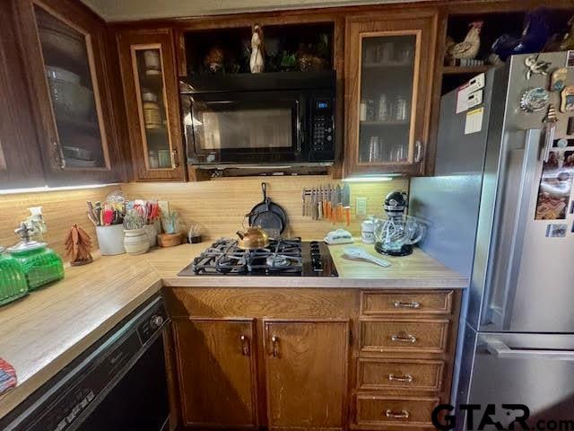 bar featuring decorative backsplash and black appliances