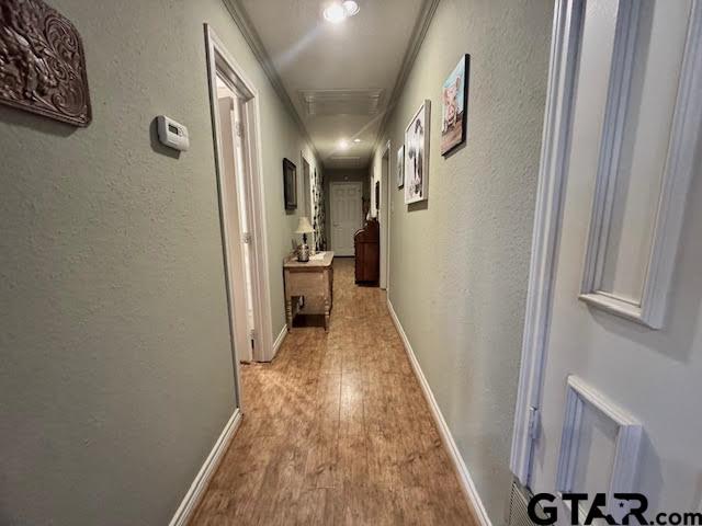 12239 Lovers Ln, Larue, TX 75770 - hall with attic access, a textured wall, light wood-style floors, and crown molding