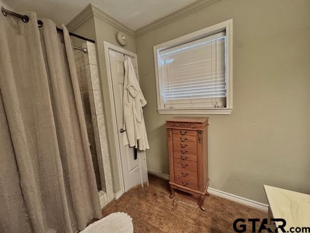 bathroom with curtained shower and crown molding