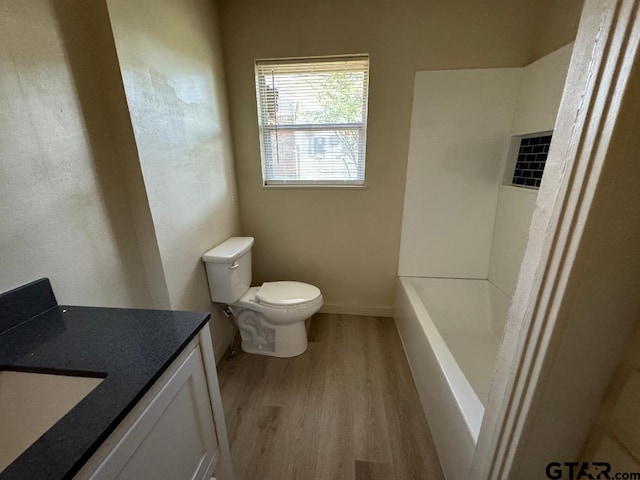 bathroom with toilet, vanity, and hardwood / wood-style flooring