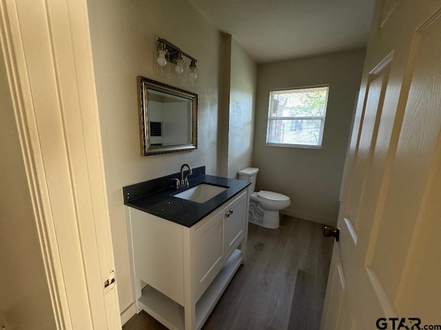 bathroom featuring wood-type flooring, vanity, and toilet