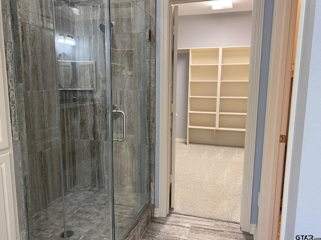 bathroom featuring wood-type flooring and a shower with door