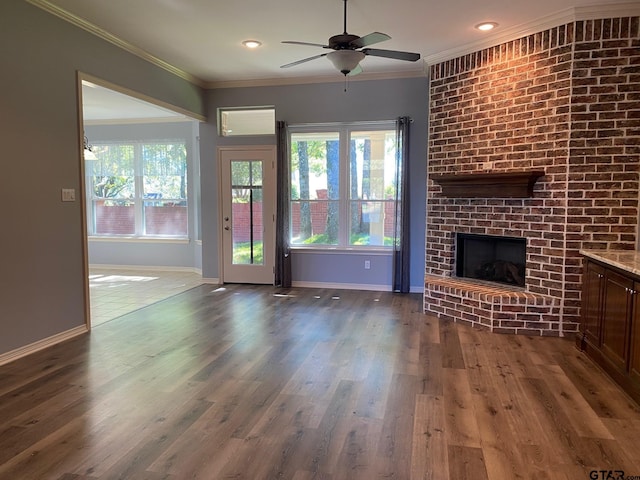 unfurnished living room featuring a wealth of natural light, dark hardwood / wood-style flooring, and crown molding