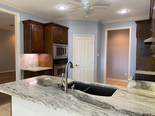 kitchen with decorative backsplash, sink, light tile patterned floors, and stainless steel appliances