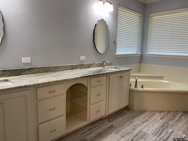 bathroom with hardwood / wood-style flooring, vanity, and a tub