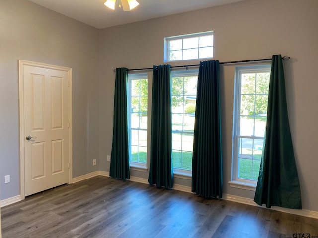 unfurnished room with ceiling fan, a healthy amount of sunlight, and hardwood / wood-style flooring