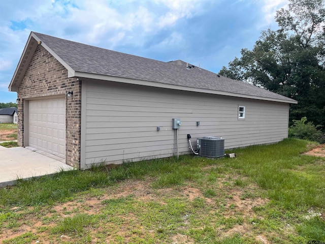 225 S Quille Ave, Mount Pleasant, TX 75455 - view of home's exterior featuring cooling unit, roof with shingles, brick siding, and a detached garage