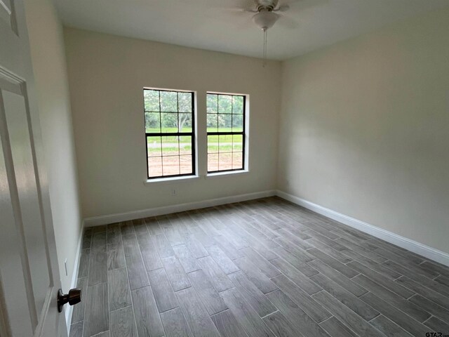 225 S Quille Ave, Mount Pleasant, TX 75455 - unfurnished room with dark wood-style floors, ceiling fan, and baseboards