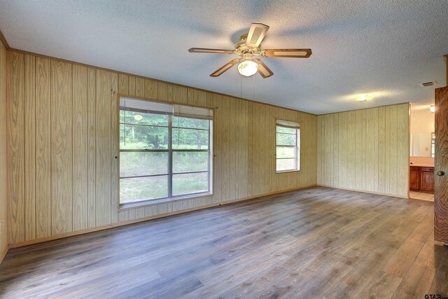 19870 Fm 1253, Lindale, TX 75771 - unfurnished room featuring wood finished floors, a textured ceiling, a ceiling fan, and wood walls