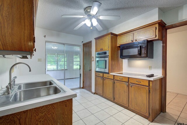 19870 Fm 1253, Lindale, TX 75771 - kitchen featuring stainless steel oven, black microwave, light countertops, brown cabinets, and a textured ceiling