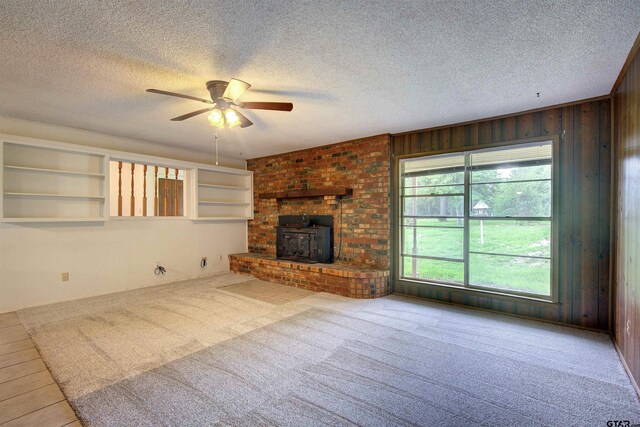 19870 Fm 1253, Lindale, TX 75771 - unfurnished living room featuring a textured ceiling, a ceiling fan, wooden walls, and carpet flooring