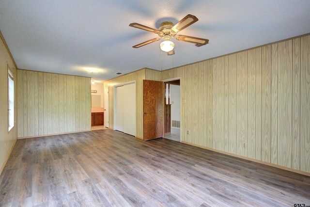 19870 Fm 1253, Lindale, TX 75771 - empty room featuring ceiling fan, a textured ceiling, wood finished floors, and wood walls