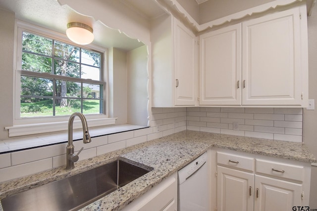 kitchen featuring white cabinets, plenty of natural light, sink, and dishwasher