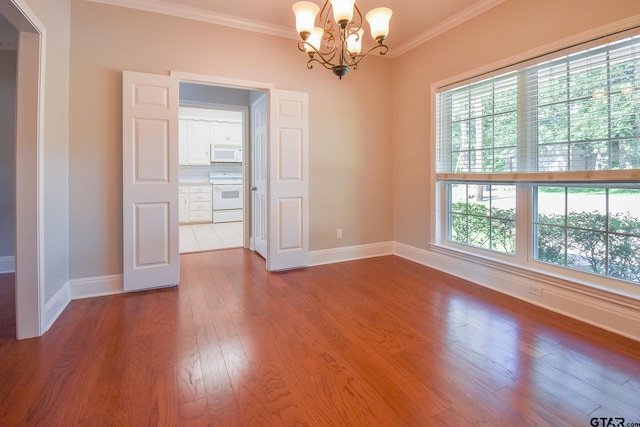 unfurnished room with wood-type flooring, crown molding, and a notable chandelier