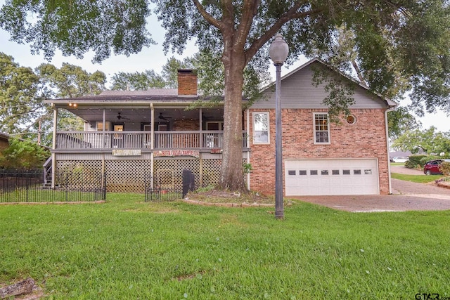 back of property with a lawn, a garage, and a wooden deck