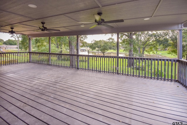 wooden deck with ceiling fan and a yard