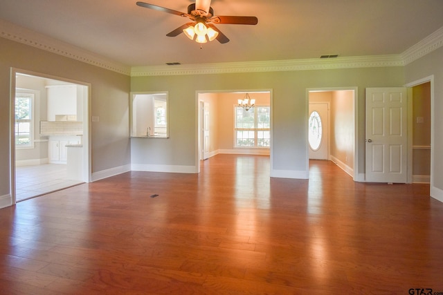 unfurnished living room featuring light hardwood / wood-style floors, ceiling fan with notable chandelier, a healthy amount of sunlight, and ornamental molding