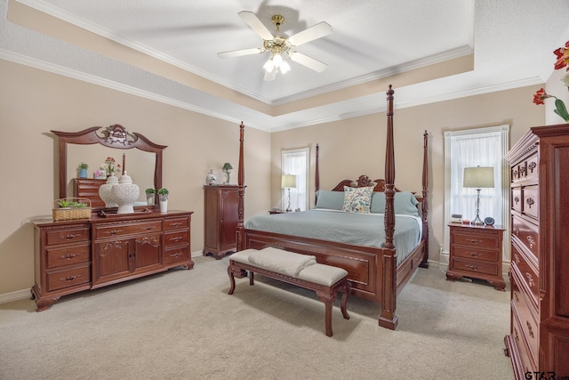 carpeted bedroom with a raised ceiling, ceiling fan, and ornamental molding