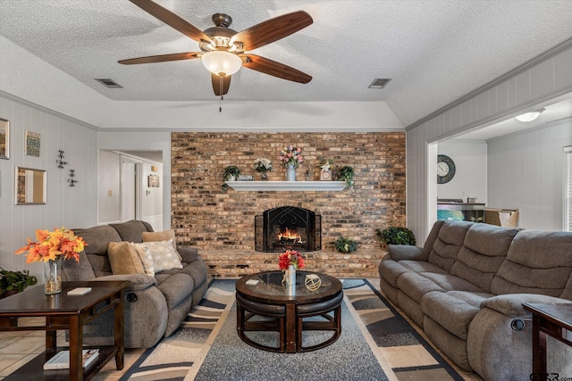 tiled living area featuring visible vents, a brick fireplace, a textured ceiling, and crown molding