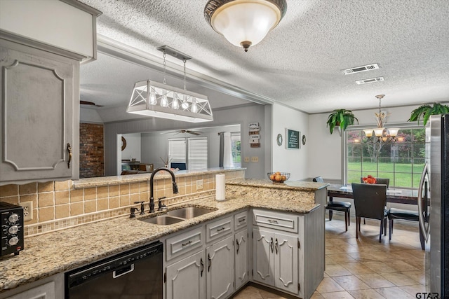 kitchen with tasteful backsplash, visible vents, dishwasher, freestanding refrigerator, and a sink