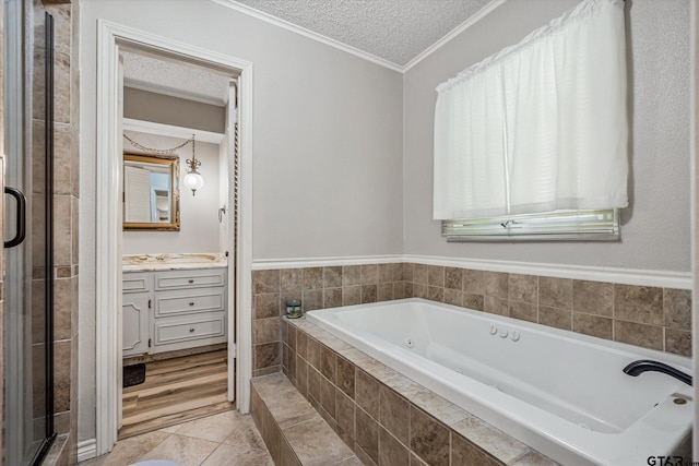 full bathroom with a shower stall, vanity, ornamental molding, a bath, and a textured ceiling