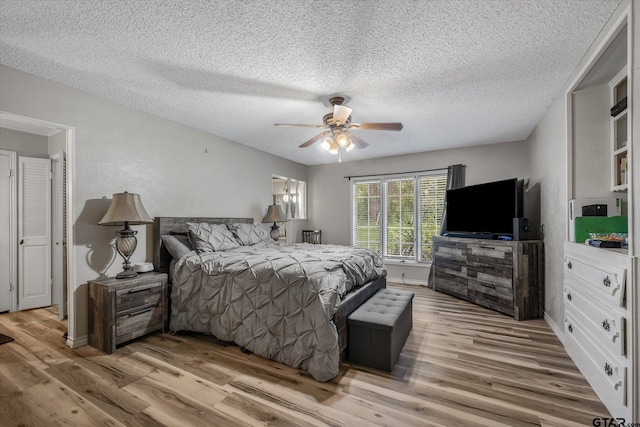 bedroom with a ceiling fan, wood finished floors, and a textured ceiling