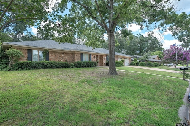 ranch-style house with a front yard, brick siding, a garage, and driveway