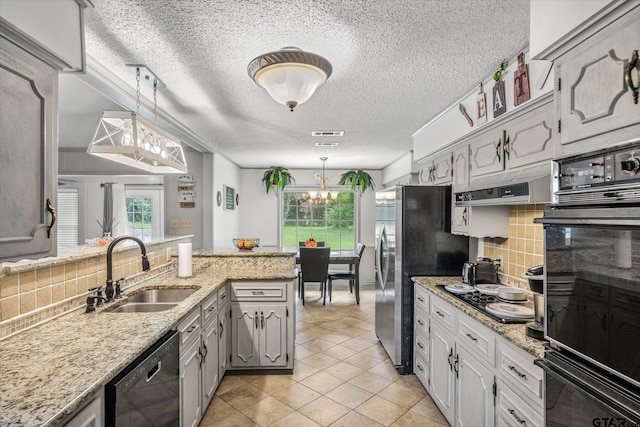 kitchen with black appliances, a healthy amount of sunlight, backsplash, and a sink