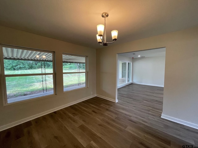 unfurnished dining area with dark wood-type flooring and a chandelier