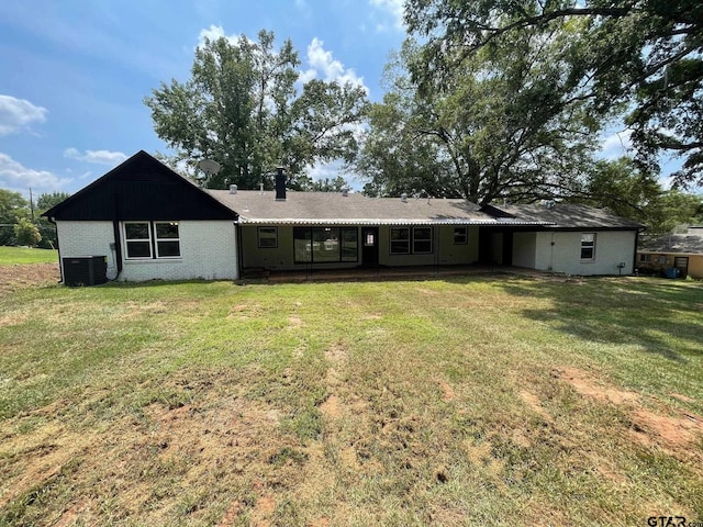 rear view of house with a lawn and cooling unit