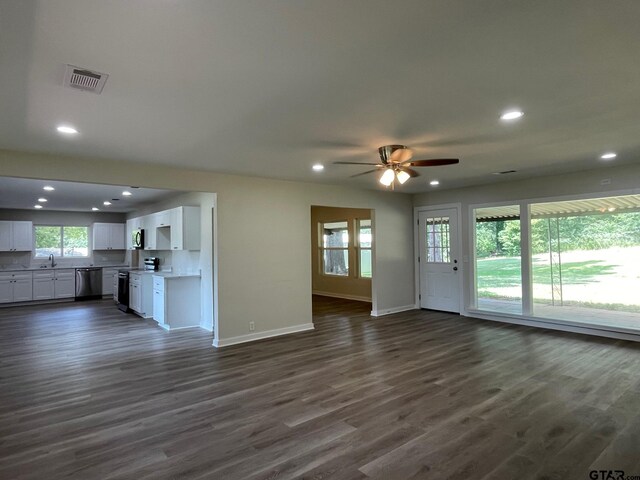 unfurnished living room with dark hardwood / wood-style floors, ceiling fan, and sink