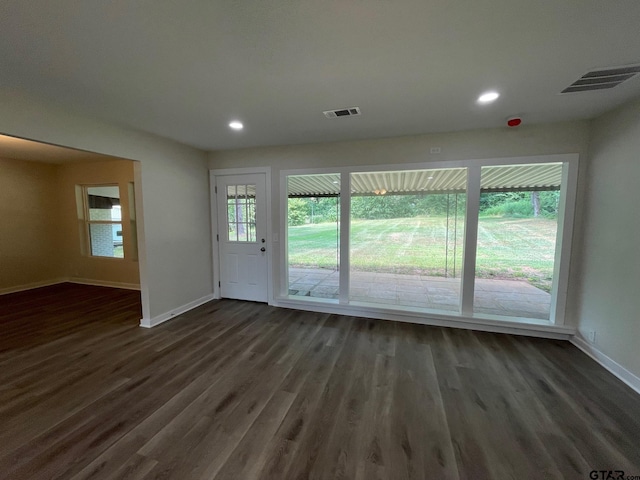 doorway with plenty of natural light and dark hardwood / wood-style flooring