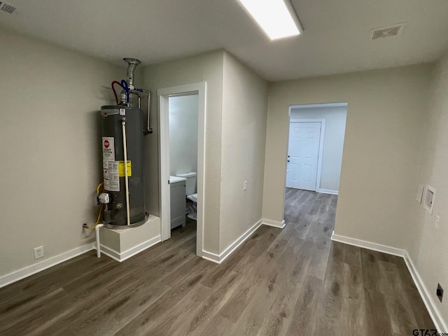 hallway featuring dark wood-type flooring and gas water heater