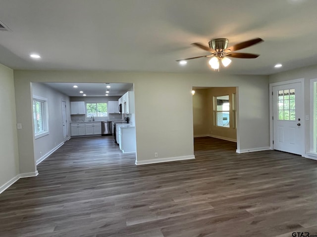 unfurnished living room with dark wood-type flooring and ceiling fan