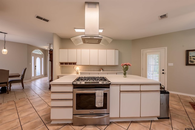 10074 Hillside Ln, Flint, TX 75762 - kitchen with stainless steel gas range oven, island exhaust hood, light tile patterned floors, light countertops, and white cabinetry