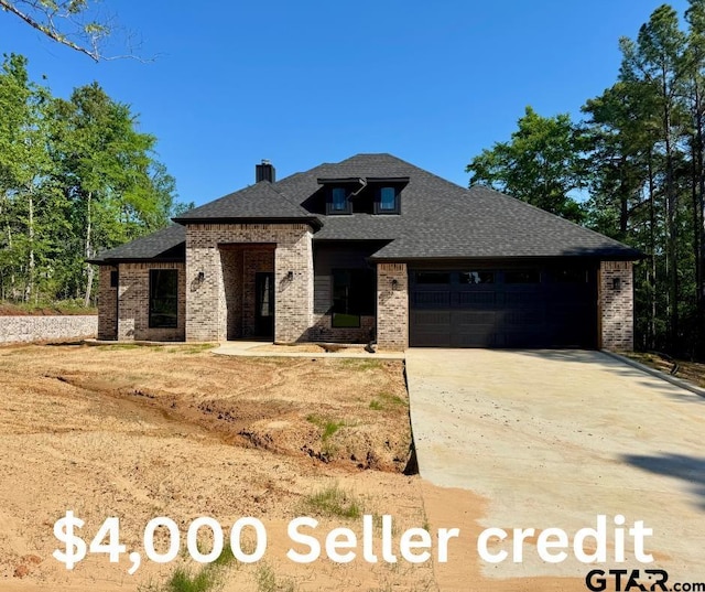 15939 Shepards Gln, Lindale, TX 75771 - view of front of home with brick siding, a garage, driveway, a shingled roof, and a chimney