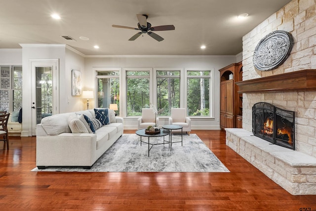1940 Stonehill Dr, Tyler, TX 75703 - living room featuring crown molding, a stone fireplace, dark wood-style flooring, ceiling fan, and recessed lighting