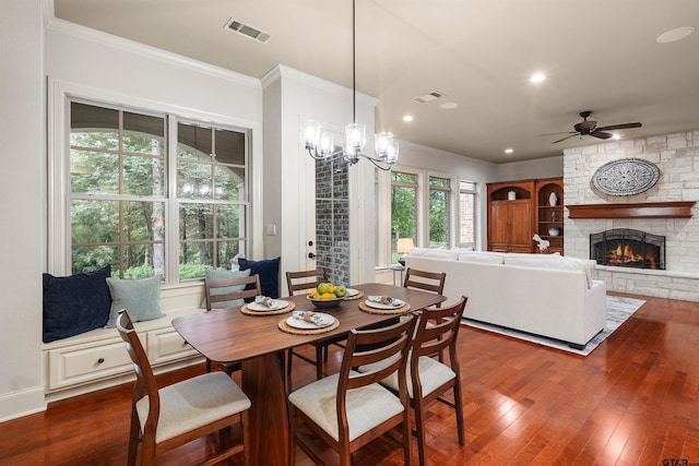 1940 Stonehill Dr, Tyler, TX 75703 - dining room with a fireplace, ceiling fan, dark wood-style floors, crown molding, and a chandelier