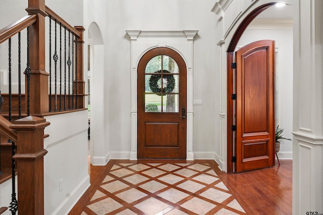1940 Stonehill Dr, Tyler, TX 75703 - foyer entrance with arched walkways, light wood-style floors, inlaid floor details, and stairway