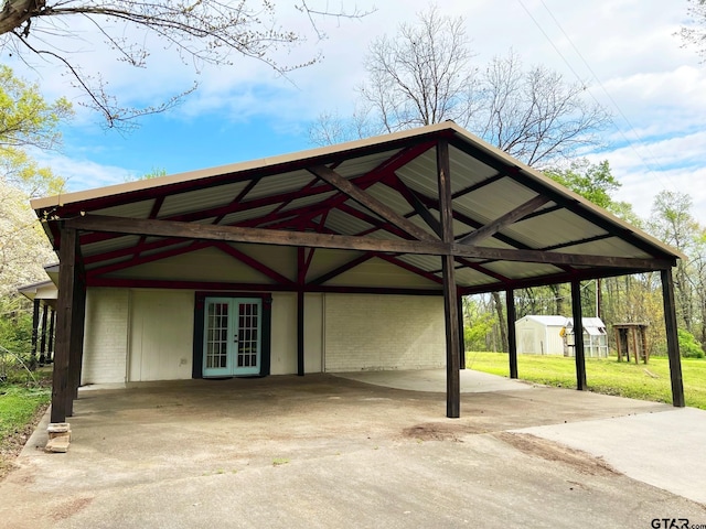 view of car parking featuring a yard and french doors