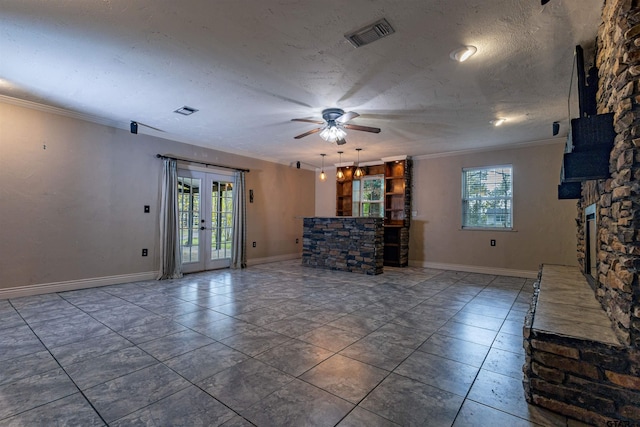 unfurnished living room with ceiling fan, a wealth of natural light, french doors, and ornamental molding