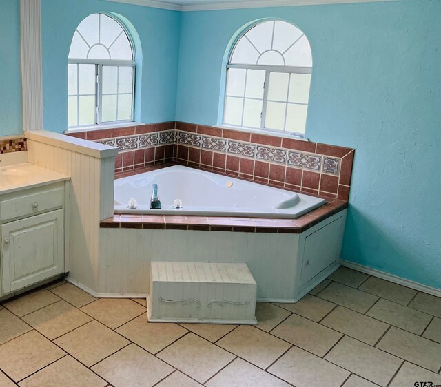 bathroom with vanity, tile patterned floors, tiled tub, and ornamental molding