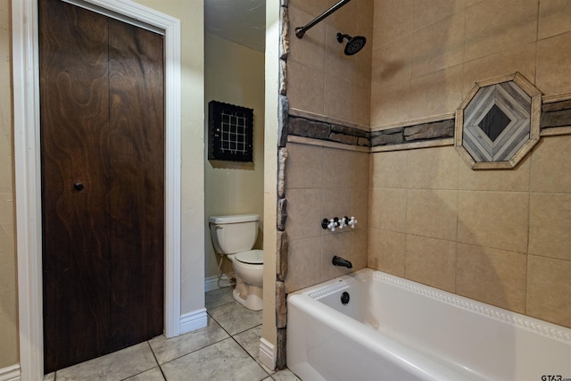 bathroom with tile patterned flooring, tiled shower / bath, and toilet