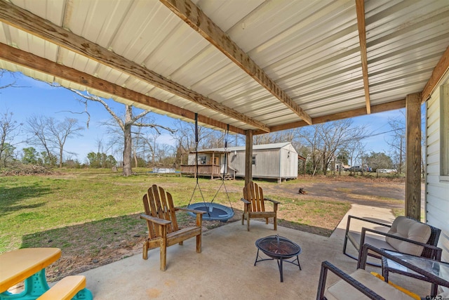 view of patio with a storage shed, an outdoor fire pit, and an outdoor structure